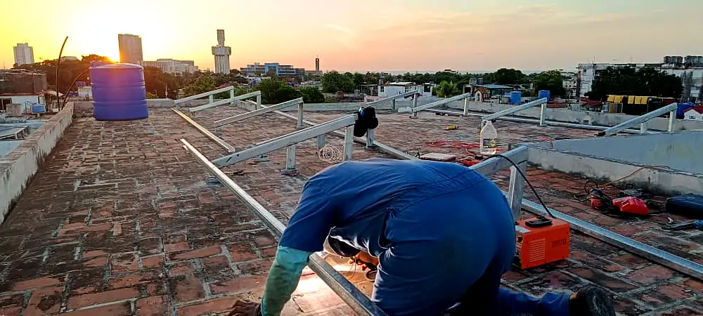 Técnico soldando la estructura al atardecer